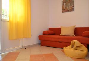 a living room with a couch and a yellow curtain at Apartment Kolundzic in Novi Vinodolski