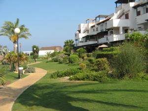 a large apartment building with a green lawn and a path at Apartamento MPS Jardines de Nuevo Vera in Vera