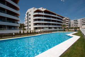 a swimming pool in front of two apartment buildings at Apartamentos Calpestabili in Altea