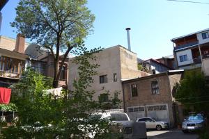 トビリシにあるTbilisi Apartment 2の車が建物の前に停まった街道
