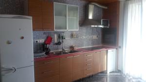 a kitchen with wooden cabinets and a white refrigerator at R&G Pineda Apartamento in La Pineda