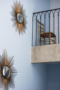 a chair and two mirrors on a wall at Le Clos Saluces in Avignon