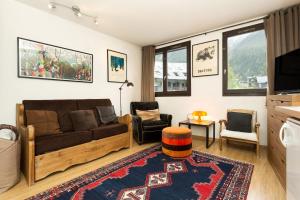 a living room with a couch and chairs and a television at Apartment Gentianes in Chamonix-Mont-Blanc