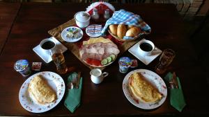 una mesa de madera con platos de comida. en Apartamenty Smętek, en Ełk