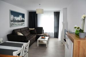 ein Wohnzimmer mit einem Sofa und einem Tisch in der Unterkunft Apartament Solna 11 in Kołobrzeg