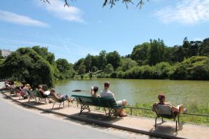 Un groupe de personnes assises sur des bancs près d'une rivière dans l'établissement Cozy Select, à Paris