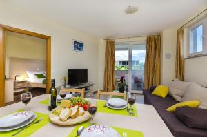 a living room with a table with food and wine glasses at Apartments Glavan in Privlaka