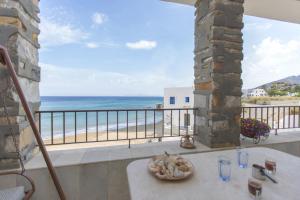 a table on a balcony with a view of the beach at Moutsouna Beach in Moutsoúna