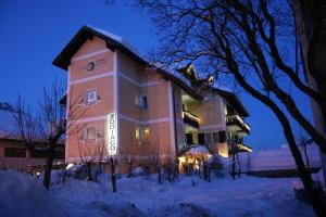 duży budynek w śniegu w nocy w obiekcie Hotel Allo Zodiaco w Andole