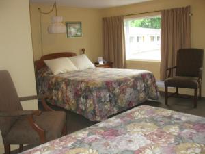 ein Hotelzimmer mit 2 Betten und einem Fenster in der Unterkunft Picket Fence Motel in Saint Andrews