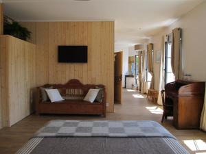 uma sala de estar com um sofá e uma televisão de ecrã plano em A L'ecole Buissonniere em Honfleur