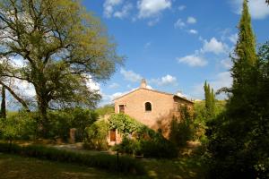 an old stone house in a garden with trees at Podere SantaAdele in Montepulciano
