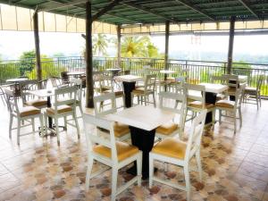 a restaurant with tables and chairs on a balcony at LEOS Hotel in Tomohon