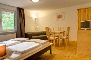 a bedroom with a bed and a table and a couch at Biohotel Spöktal in Bispingen