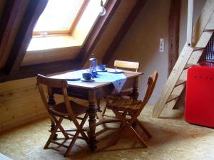 una mesa de madera y sillas en una habitación con ventana en Ferienwohnungen Taubenschlag, en Creglingen