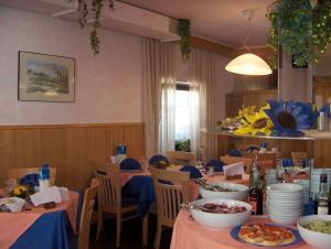 jadalnia ze stołami i krzesłami z jedzeniem w obiekcie Hotel Allo Zodiaco w Andole
