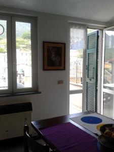 a dining room with a table and two windows at Casa Elsa in Corniglia