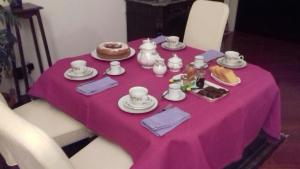 a table with a pink table cloth with food on it at A Casa di Renata in Cosenza