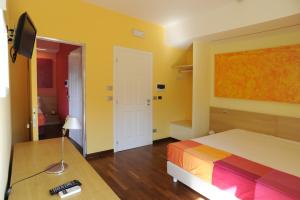 una camera da letto con un letto, una scrivania e una televisione di Affittacamere Stazione Valmontone a Valmontone