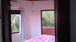 a mirror in a room with a bed and a window at Apartamento Forte in Praia do Forte