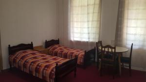 2 posti letto in una camera con tavolo e sedie di Firuza Hostel a Borjomi