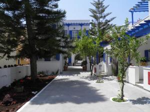 a large white building with a tree in front of it at Levante Beach Hotel in Kamari