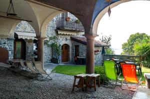 a group of chairs sitting outside of a building at Castello di Zorzino Iseo lake in Riva di Solto