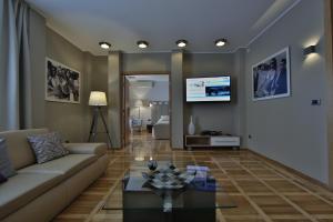 een woonkamer met een bank en een tv aan de muur bij Aber Apartment in Belgrado