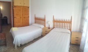 two beds in a bedroom with white sheets at Lecoron in Águilas