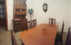 une salle à manger avec une table, des chaises et une horloge dans l'établissement Lecoron, à Águilas