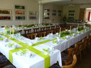 a long dining room with white tables and candles at Hotel Zum Birkenhof in Burow