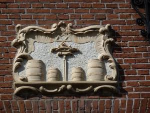 un panneau sur un mur de briques avec un bouquet de tasses dans l'établissement It Buterhus, à Balk