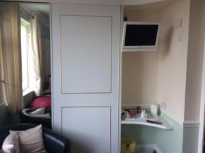 a white door in a room with a tv at Alma Lodge Guest House in Plymouth