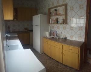 La cuisine est équipée d'un réfrigérateur blanc et de placards en bois. dans l'établissement Lecoron, à Águilas