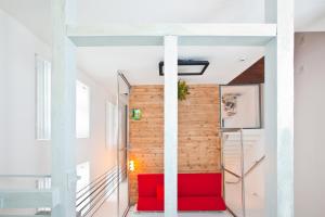 a red bench in a hallway with a brick wall at Historic courtyard house in the center in The Hague