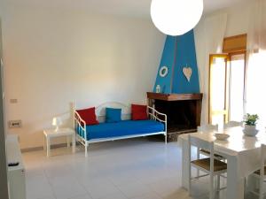 a living room with a blue couch and a table at Appartamento Aria 150m dal mare in Castelsardo