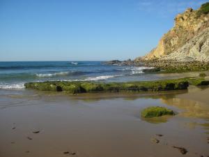 a beach with some rocks and the ocean at Aurora Sol in Luz