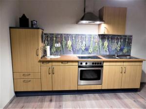 a kitchen with wooden cabinets and a stove at Ferienwohnung Seibt in Plettenberg