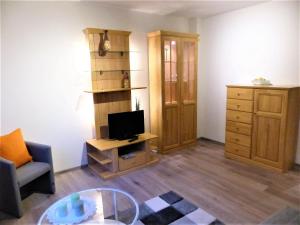 a living room with a desk with a television and a cabinet at Ferienwohnung Seibt in Plettenberg