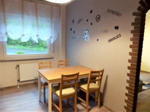 a dining room with a wooden table and chairs at Ferienwohnung Seibt in Plettenberg +2 photos