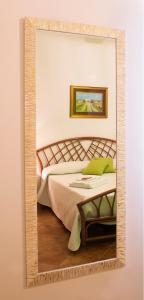 een spiegel aan een muur in een slaapkamer bij Villa Franca in Noci
