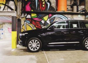 a black car parked in front of a wall with graffiti at Hôtel In Situ in Béziers