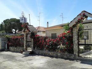 サンテーラモ・イン・コッレにあるB&B Villa Paradisoの家の前に赤い花の柵