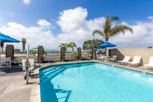 Capistrano Beach的住宿－卡皮斯特拉諾瑟夫賽德酒店，度假村的游泳池,配有椅子和遮阳伞