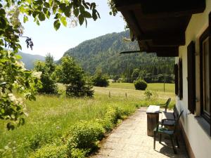 eine Veranda mit 2 Bänken und Blick auf ein Feld in der Unterkunft Seewiesenalm in Reit im Winkl