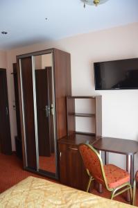 a room with a desk and a table and a tv at Dormed Medical SPA in Busko-Zdrój