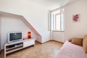 a living room with a tv and a couch at Apartmani Aligator in Primošten