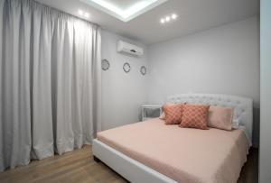 a white bedroom with a bed with two pillows on it at Pineapple Seaside Suite in Zakynthos