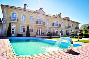 une grande maison avec une piscine et une fontaine dans l'établissement Hotel Villa Venice, à Vinnytsia