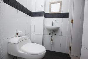 a white bathroom with a toilet and a sink at Hotel Murano in Abancay
